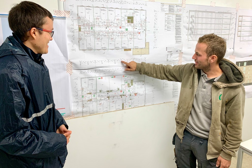 Patrick laat aan Kevin de bouwtekeningen zien.