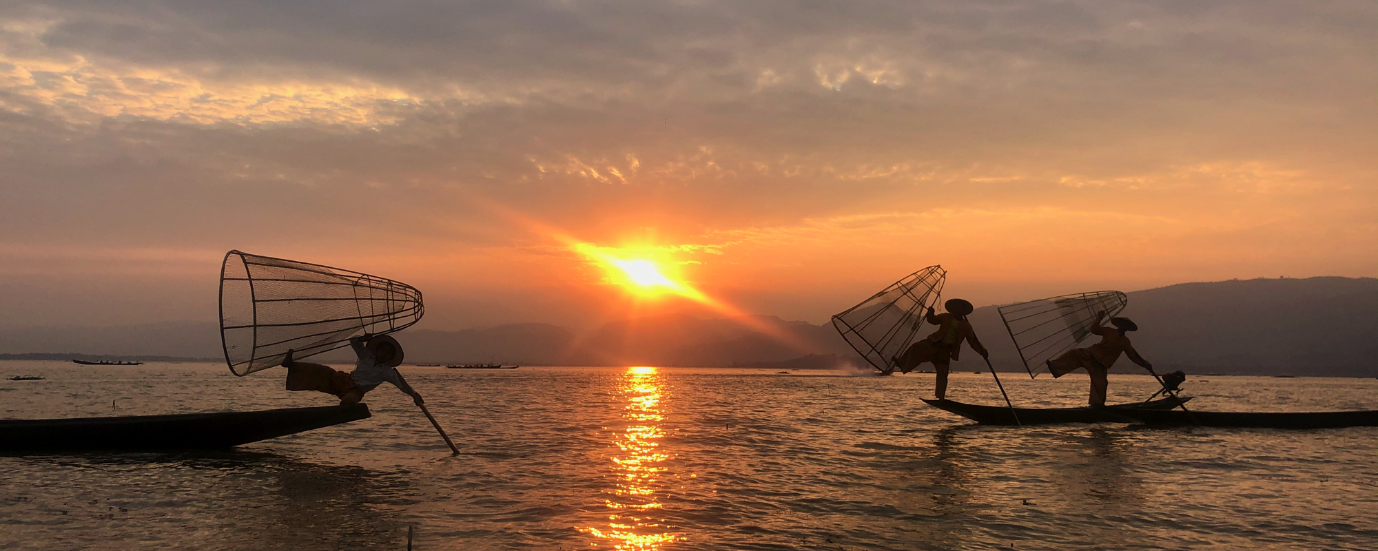 Aziatische vissers in de avondzon